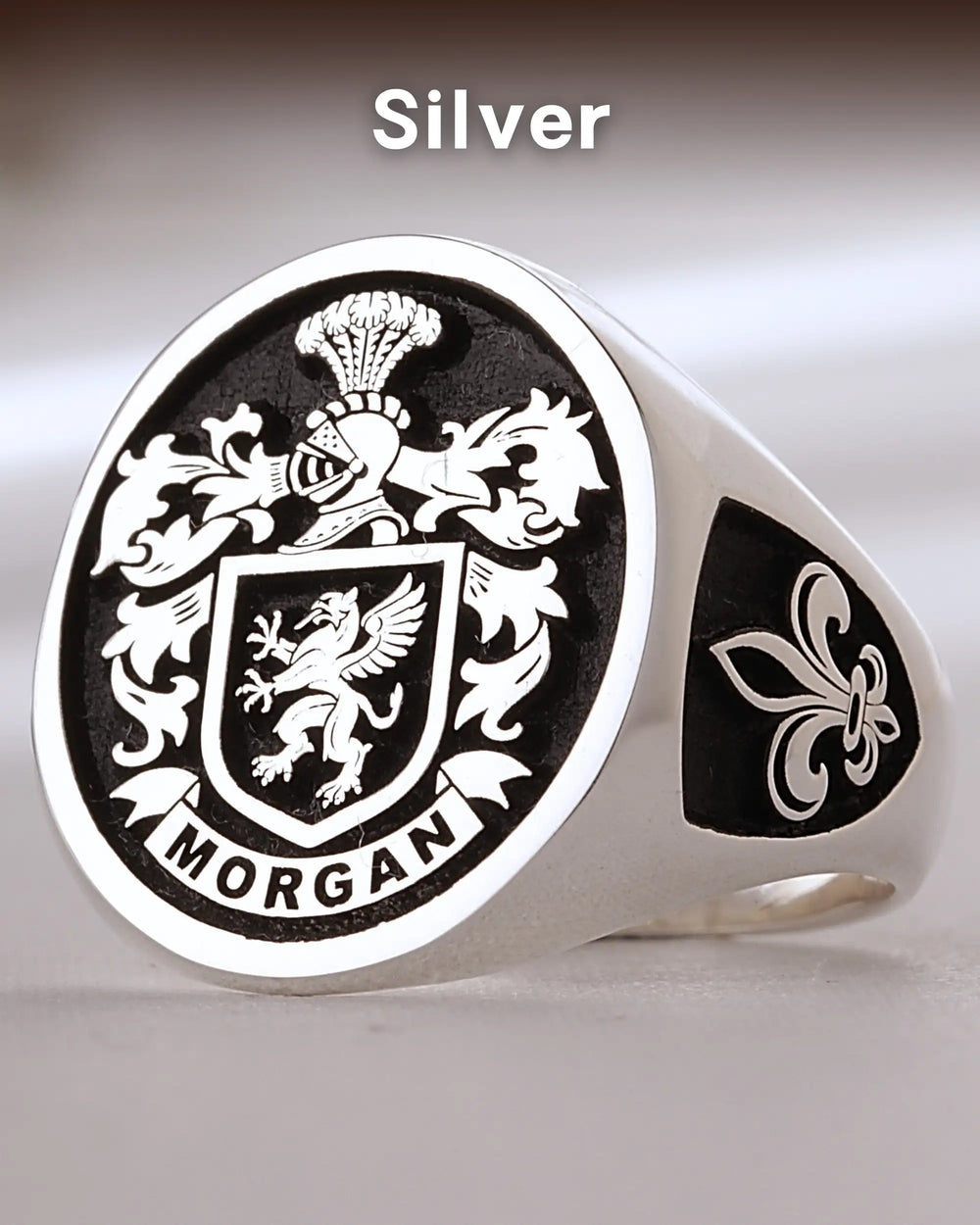 Silver-finish custom signet ring with the Morgan family crest engraved on a black background and a fleur-de-lis on the side